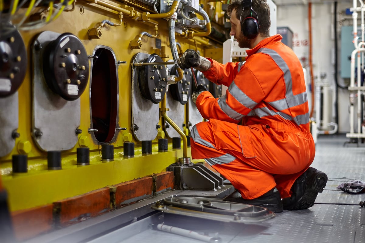 Engineer inspecting the condition of a main engine block