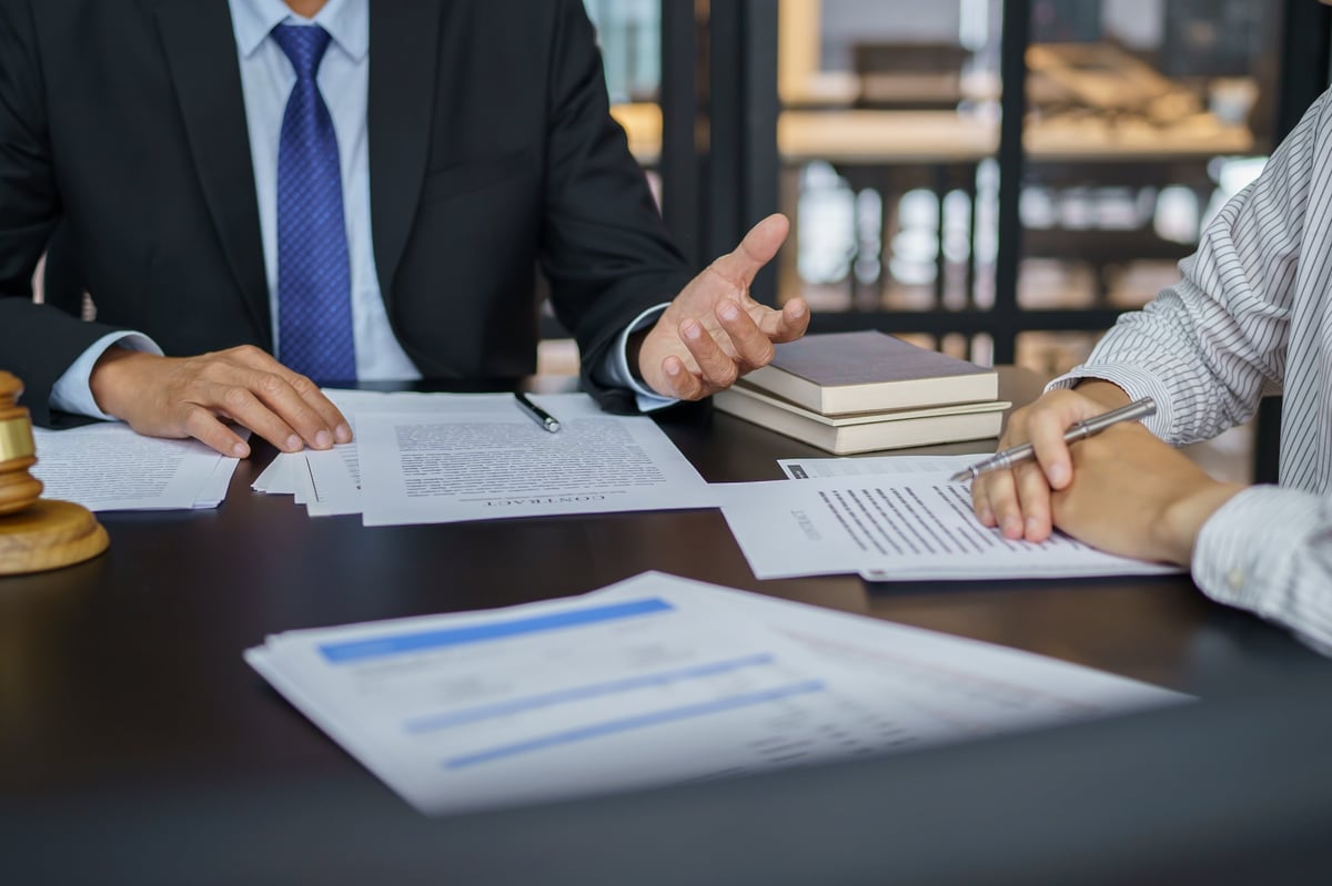Signed contract and documentation laid out on a desk during a business meeting